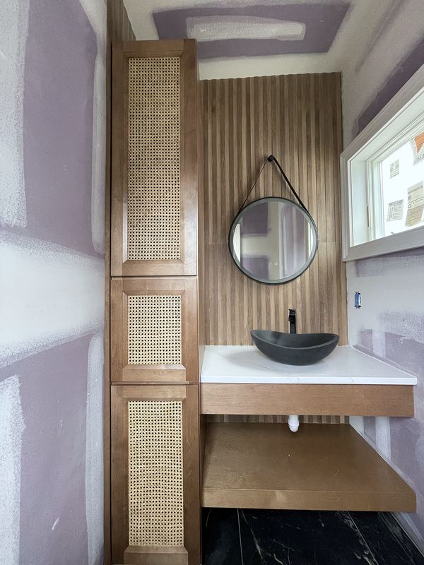 Powder room with slatted wood wall, vessel sink and floating vanity