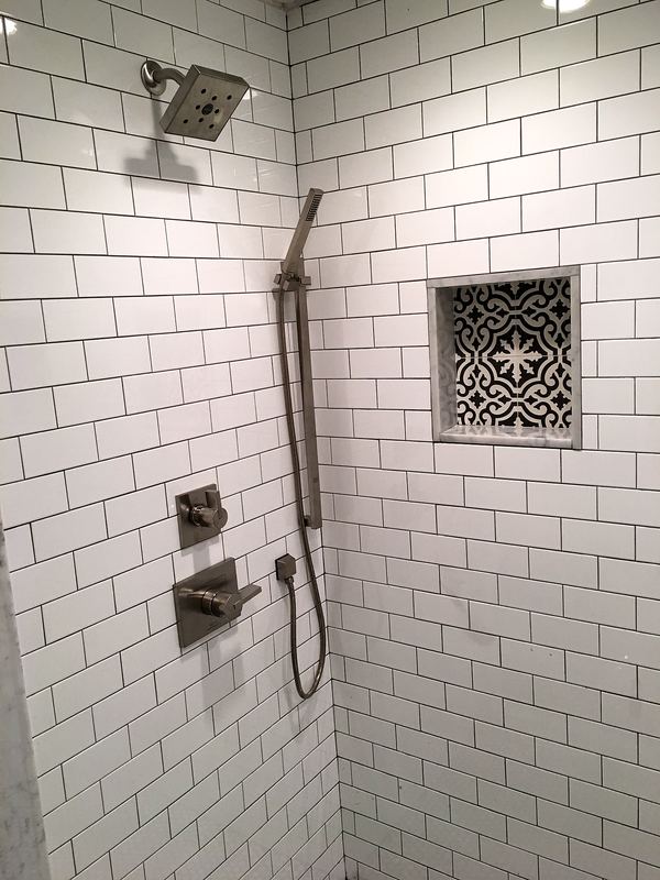 Subway tile shower with rain head and niche