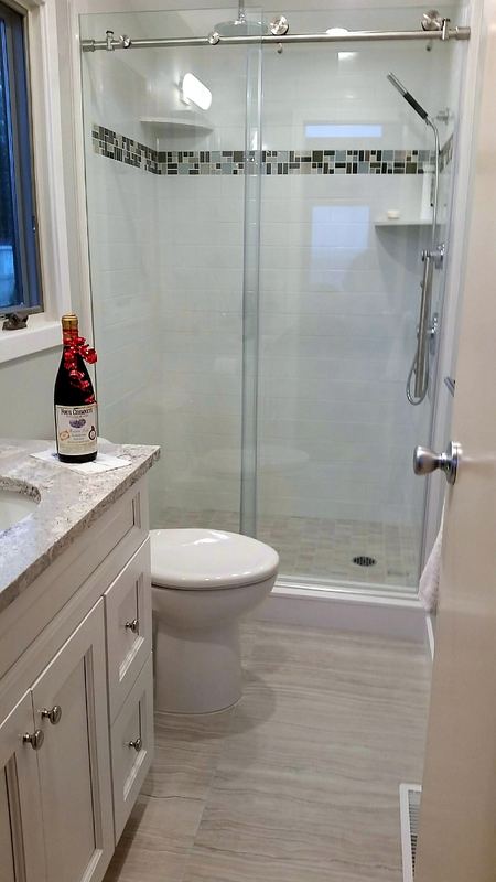 Glass shower enclosure with white vanity