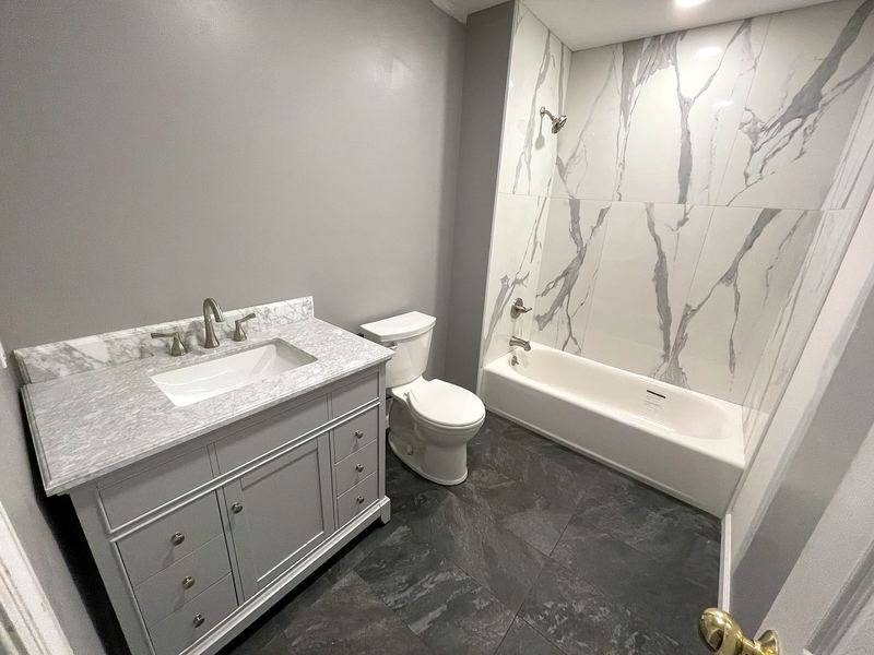 Gray vanity with marble-look tub surround