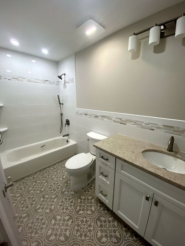Tub with tile wainscot and patterned floor