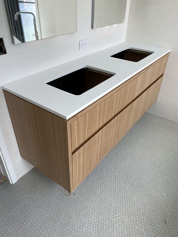 Floating wood vanity with double sinks and white quartz top