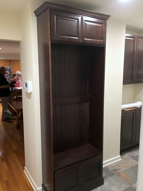 Built-in mudroom locker in dark stained wood