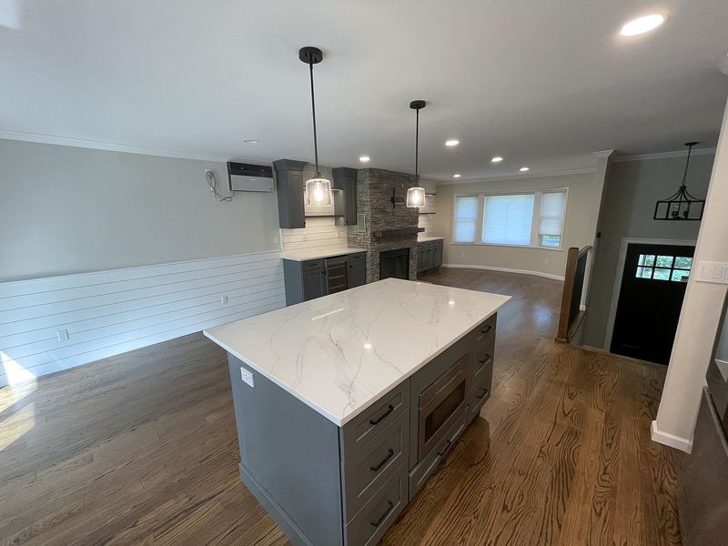 Kitchen with gray island, white quartz and pendant lights