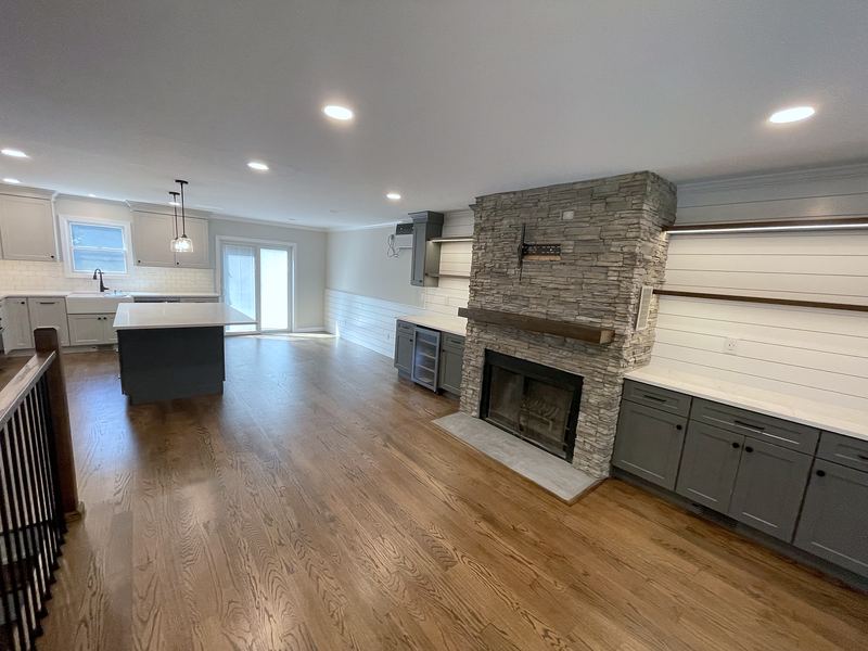 Open kitchen and living area with stacked stone fireplace