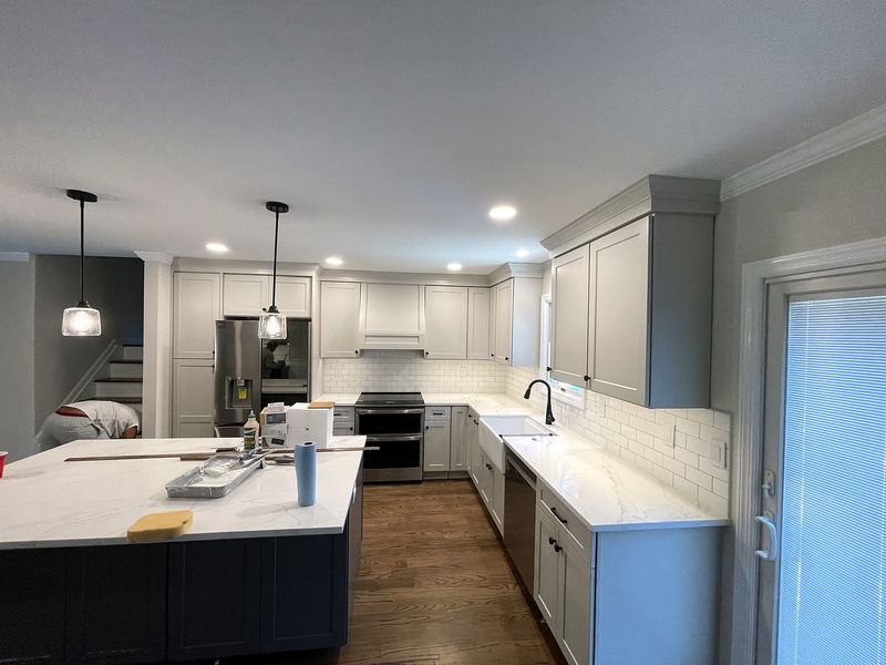 Two-tone kitchen with navy island and gray perimeter cabinets