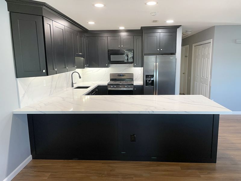 Black kitchen with white quartz peninsula