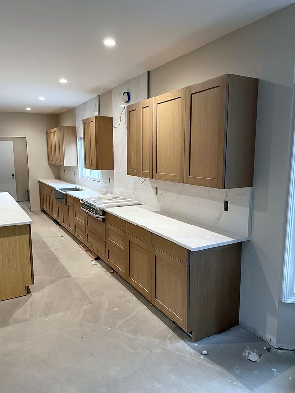 Galley kitchen with wood-tone shaker cabinets and white quartz