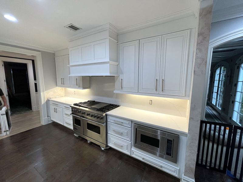 White kitchen with range hood and under-cabinet lighting