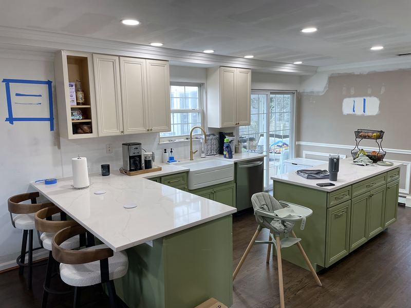 Cream kitchen with sage green island and seating