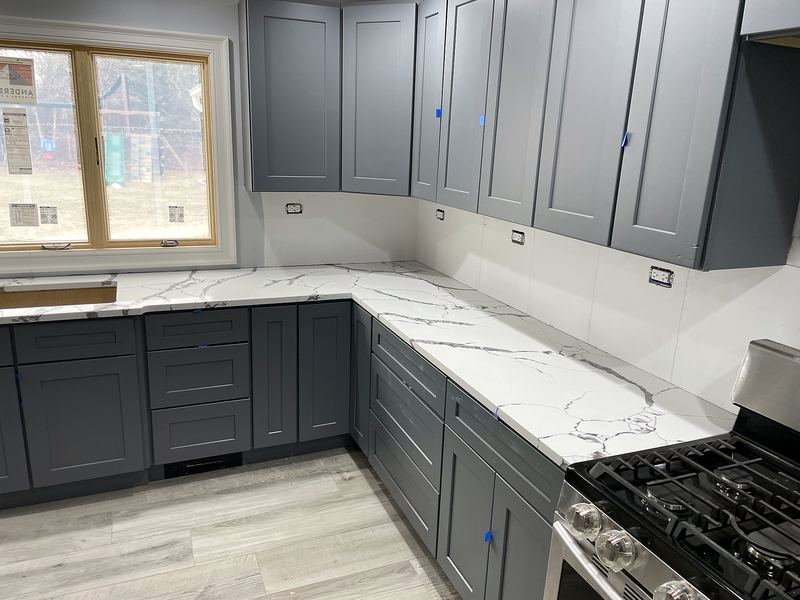 Charcoal gray kitchen with white quartz countertops
