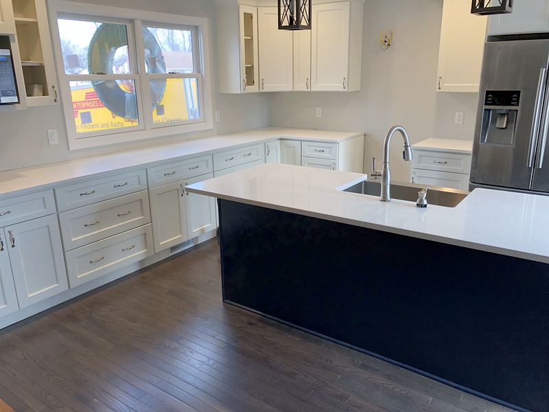 White kitchen with navy island and quartz top
